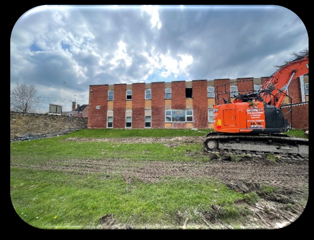 L A Moore excavator beside former school buildings in Yeovil